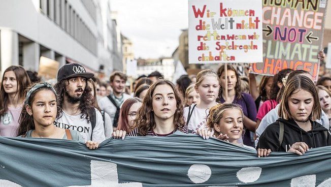 Junge Menschen mit Transparenten auf einem Klimaprotest