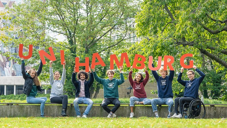 Studierenden halten Buchstaben Uni Hamburg hoch