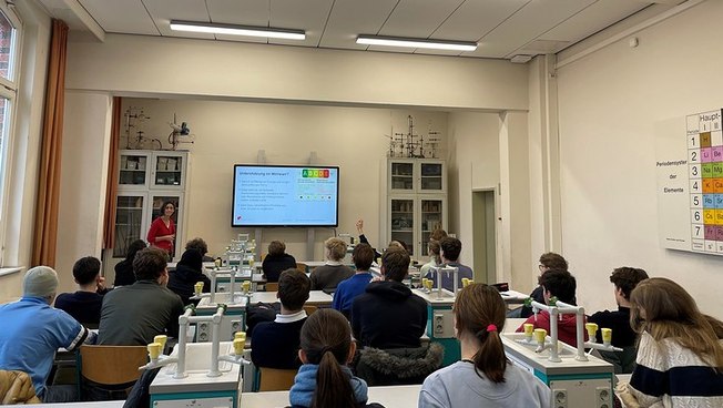 High school students listening to a researcher