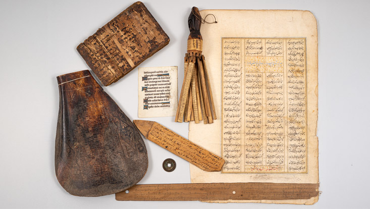 uwa-20-733x414 Eine Sammlung historischer Schriftstücke und Schreibutensilien aus verschiedenen Kulturen.