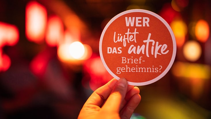 Was erreicht gute Wissenschaftskommunikation? Ein Bierdeckel von Wissen vom Fass mit der Frage, wer das antike Briefgeheimnis lüftet