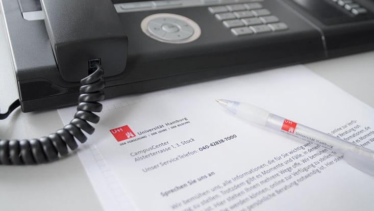 Telefon mit Zettel und Kugelschreiber