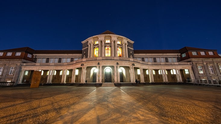 Das erleuchtete Hauptgebäude der Universität bei Nacht