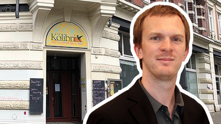 Porträtfoto des Vortragenden Lukas Brunner vor dem Hintergrund des Veranstaltungsortes Kölibri