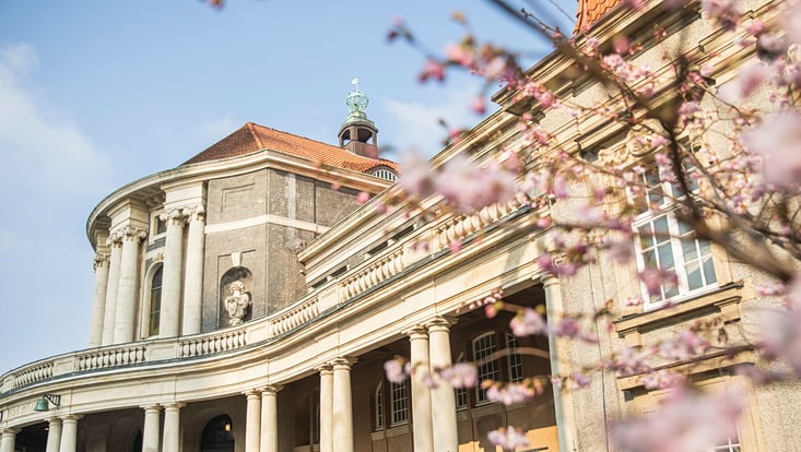 Blick auf das ESA Hauptgebäude. Unscharf sind am Rand Kirschblüten zu erkennen.