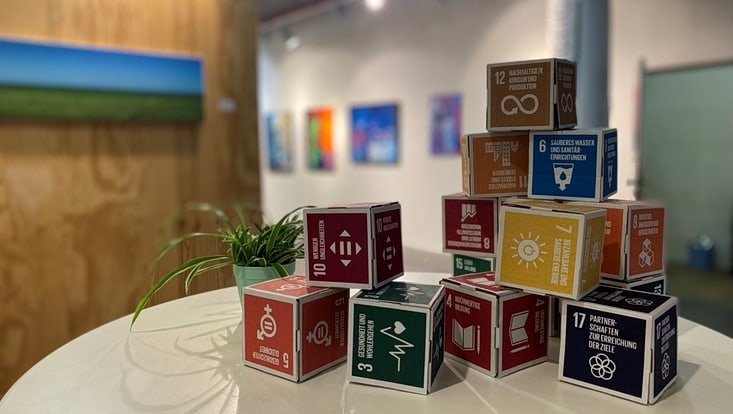 02-03-vernetzung-nachhentwi-ebene-2-teaser-cuhh-mendes-733x414 Würfel auf denen die Sustainable Development Goals stehen sind zu einer Pyramide aufgebaut