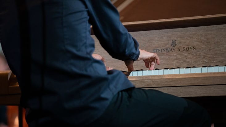 Ein Musiker vor dem neuen Konzertflügel im Audimax