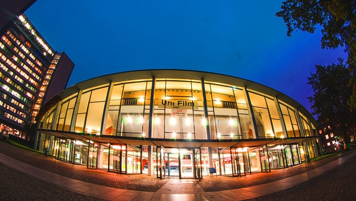 Frontansicht des beleuchteten Audimax bei Nacht