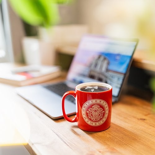 Laptop und rote UHH-Tasse