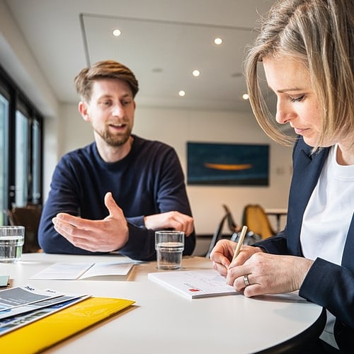 Beratungssituation mit zwei Personen an einem Tisch