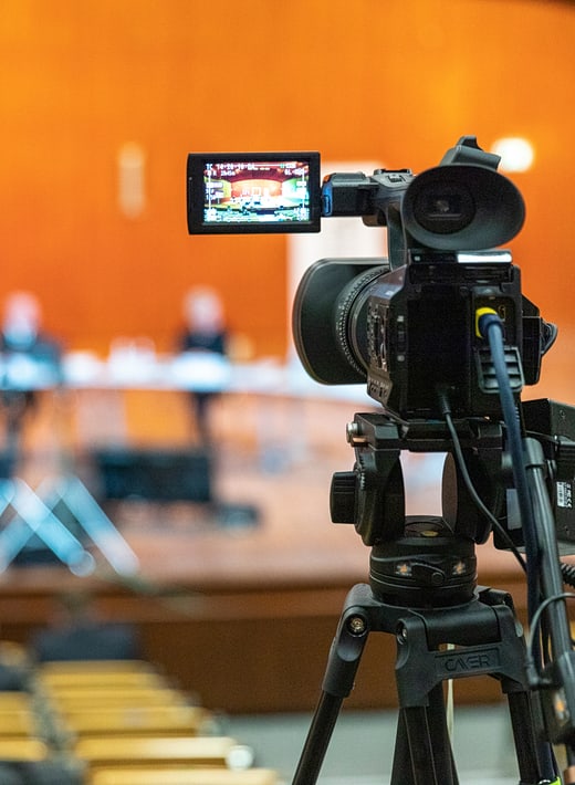 Fotos und Videos Eine Kamera in Nahaufnahme, die ein Podium filmt