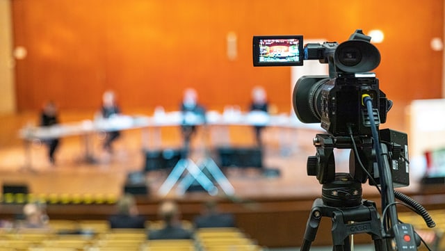 Fotos und Videos Eine Kamera in Nahaufnahme, die ein Podium filmt