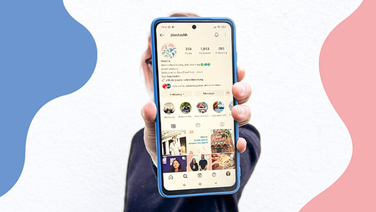 Eine Person hält ein Handy in der Hand. Auf diesem ist der Instagram Account von PIASTA zu sehen