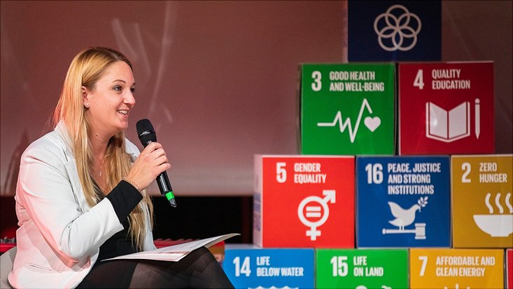 CSO Laura Edinger-Schons auf dem Podium mit SDG-Würfeln