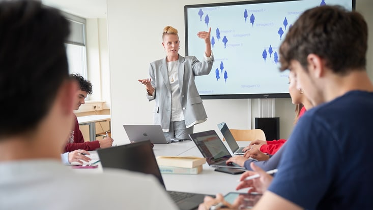 Symbolbild: Workshop-Situation mit Dozentin vor einem Smartboard