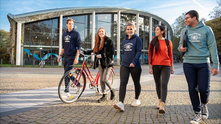 Mehrere Studierende laufen über den Campus