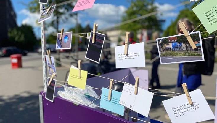 Fotos und beschriftete Karten mit Wäscheklammern an einer Leine befestigt