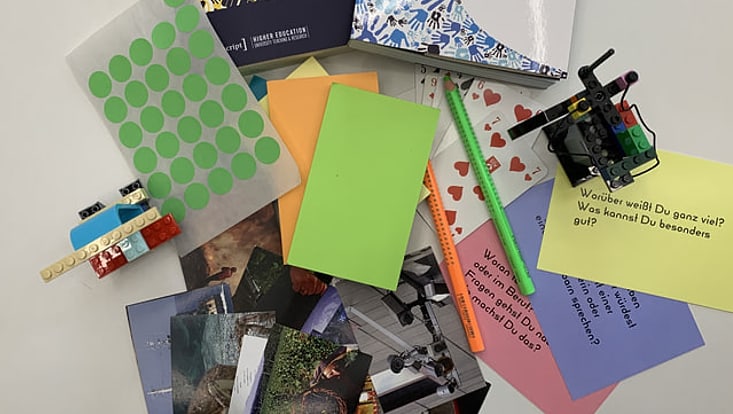 Foto eines Stapels von Materialien wie Büchern, Fotos und Notizzetteln