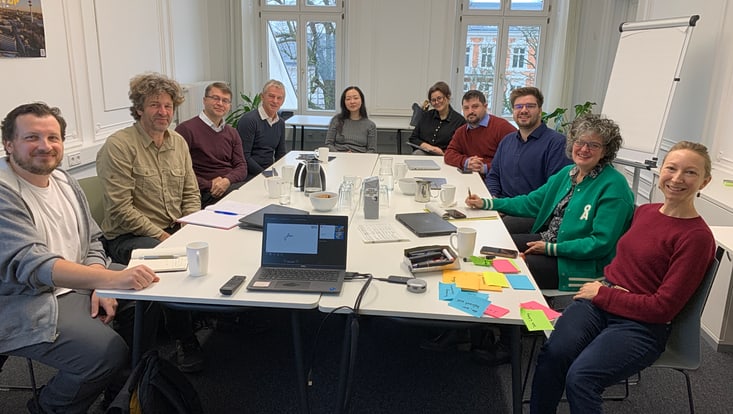 20251125-tf-kick-off-cucaser-(20)-733x414 Personen sitzen an einem Tisch in einem Raum und lächeln in die Kamera