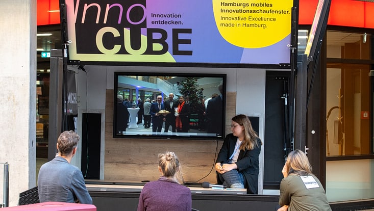 2025-09-19-cmc-t-02-alena-zielinski-(131)-733x414 Innocube: Zuschauende sitzen vor einer vortragenden Person und einem Bildschirm