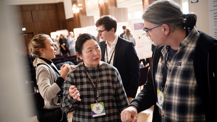 Teilnehmende des Forum Citizen Science 2024 betrachten Poster und sprechen miteinander