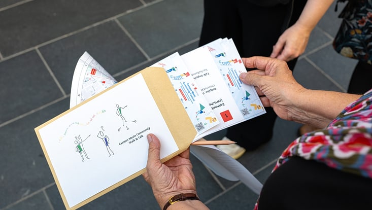 2025-09-19-cmc-t-02-alena-zielinski-(118)-733x414 Eine Person hält eine Infobroschüre in der Hand