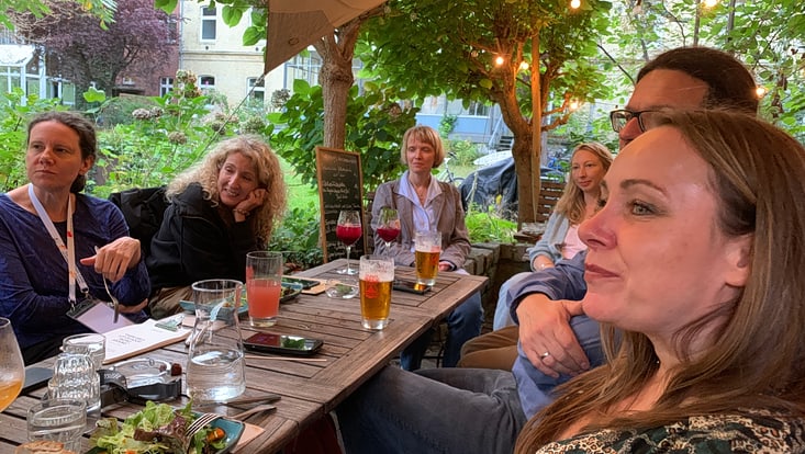 2025-09-19-hbdv-walktalk-cucaser-(12)-733x414 Mehrere Personen sitzen um einen Tisch und hören angeregt zu