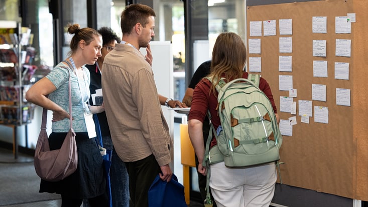 2025-09-20-cmc-t-03-alena-zielinski-(121)-733x414 Mehrere Personen stehen vor einer Pinnwand mit verschiedenen beschrifteten Karteikarten