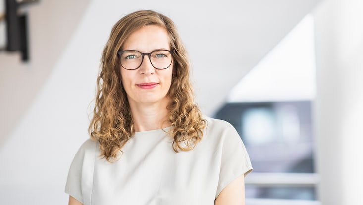 klingelhoefer-jens-maren Frau mit dunkelblonden, lockigen, schulterlangen Haaren und Brille lächelt in die Kamera.