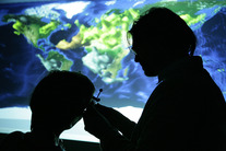 Motif of researchers in front of a map of the world
