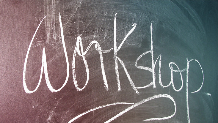 eine grüne Schultafel mit der Aufschrift Workshop welche mit Kreide beschrieben ist