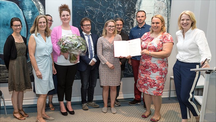 Zehn Personen in festlicher Kleidung stehen nebeneinander. Darunter neun Personen des Organisationsteam des „Mildred Dresselhaus Gastprofessorinnenprogramms“. Rechts im Bild: Vizepräsidentin Prof. Dr. Jetta Frost