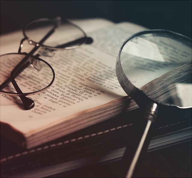 Das Bild zeigt ein altes Buch mit einer alten Lupe