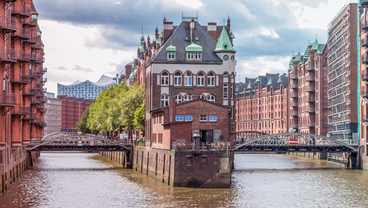 Das illustrative Bild zeigt eine Brücke über der Elbe in der Hamburger Speicherstadt