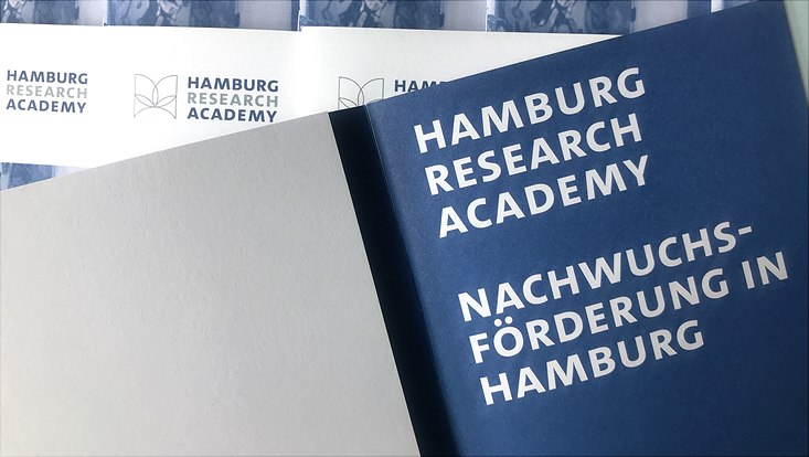 Open HRA brochure with text: Hamburg Research Academy - Nachwuchsförderung in Hamburg