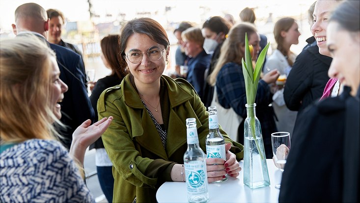 Vier Teilnehmerinnen stehen lachend an einem Stehtisch zusammen