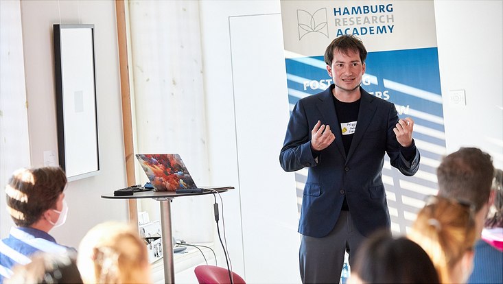 Dr. Philipp Gadow hält auf der Bühne einen "Science Slam"