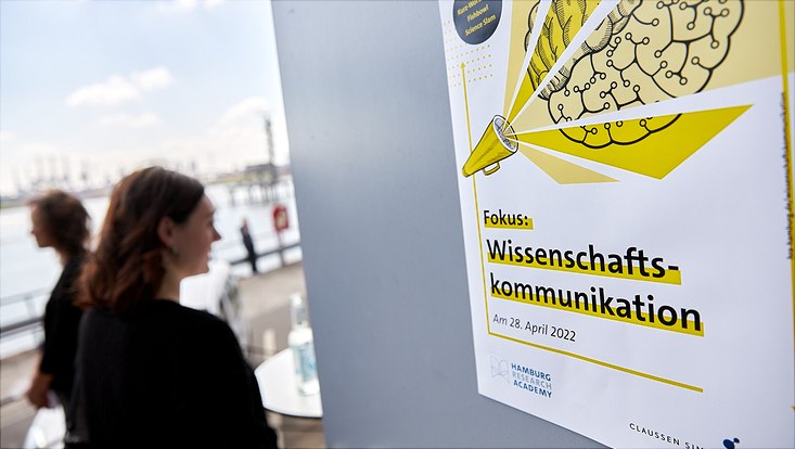 An der Eingangstür hängt das Plakat zur Veranstaltung: "Fokus: Wissenschaftskommunikation"