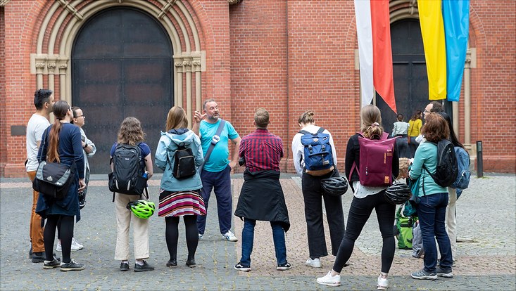 HRA Stadtrundgang The participants stand together with the guide in a circle