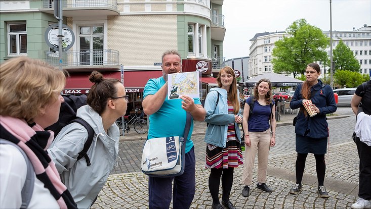 HRA Stadtrundgang The participants of the HRA City Walk stand together and listen to the city guide