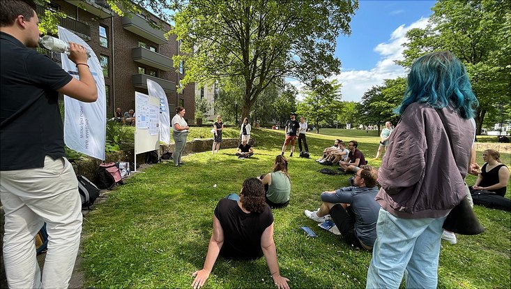 People sitting and standing together in a park