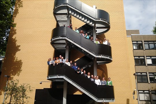 Studierende, Alumni und Mitarbeitende auf einer Außentreppe am Präsenztag des MHEs 2022.