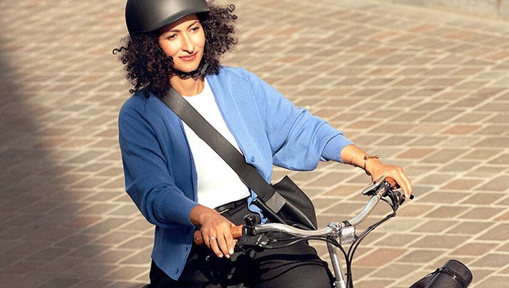 Eine be-Helmte Frau auf dem Fahrrad