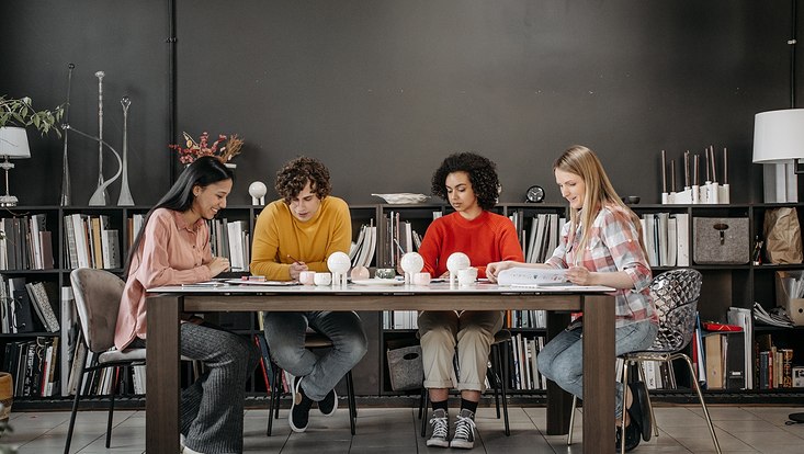 Vier Studierende schreiben am Tisch