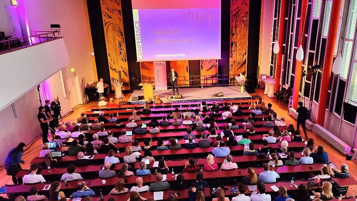 Vogelperspektive auf Publikum im Saal beim TURN-Auftakt