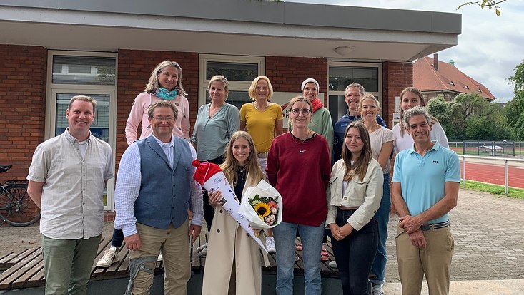 Drei Personen mit Blumenstrauß