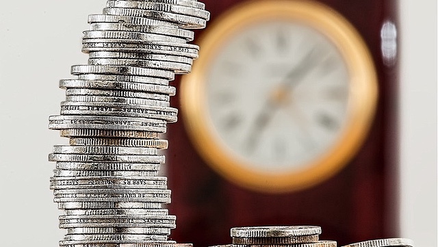 Stapel mit Geld und Uhr