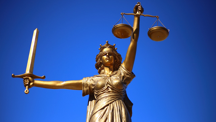 Statue der Justizia vor blauem Himmel