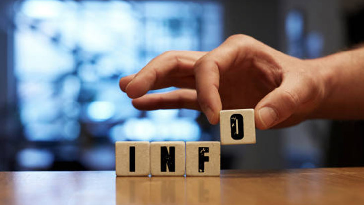 Blick auf vier Blöcke mit der Aufschrift "Info". Das "O" wird von einer Hand hingestellt.