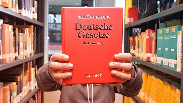 BGB hochgehalten zwischen Bücherregalen